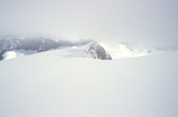 Tussen mist en sneeuw is een reepje van het panorama vanaf de top te zien.